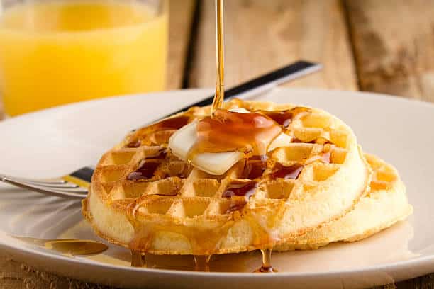 A waffle with butter and syrup on top Description automatically generated